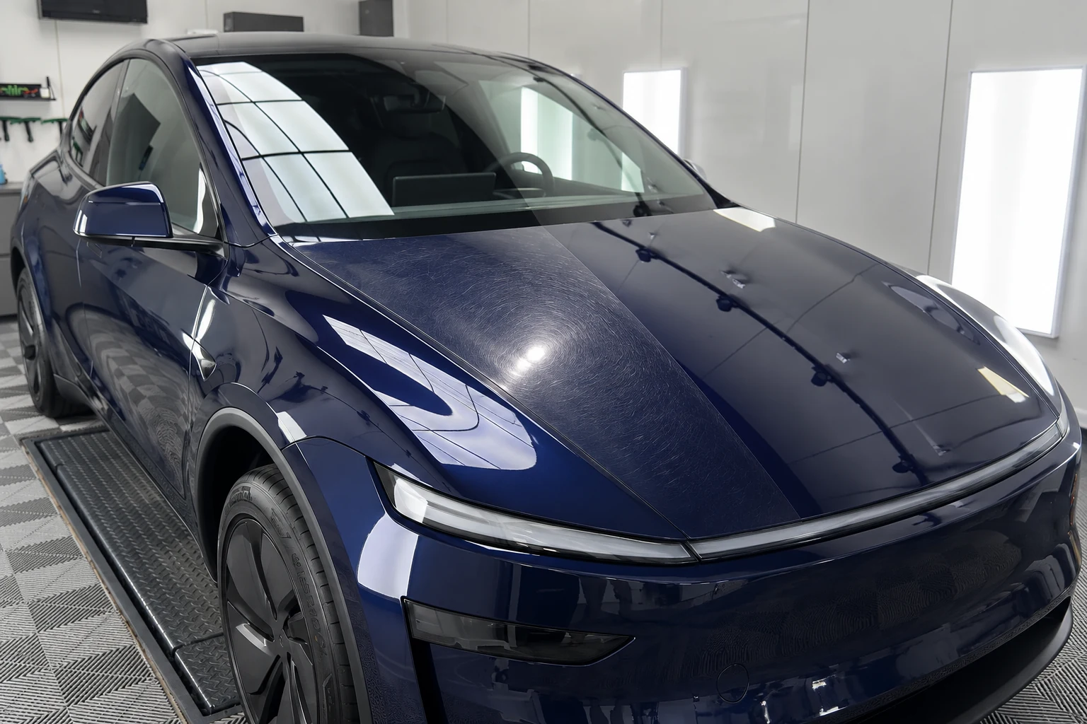 Micro-rayures visibles sur le capot d’une Tesla dans le décor de l’atelier ByFab